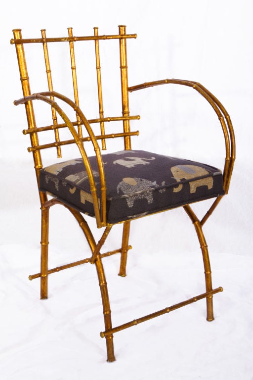 Hollywood regency gilt metal arm chair with bamboo motif and gracefully curved arms.  Reupolstered in Rodolph 