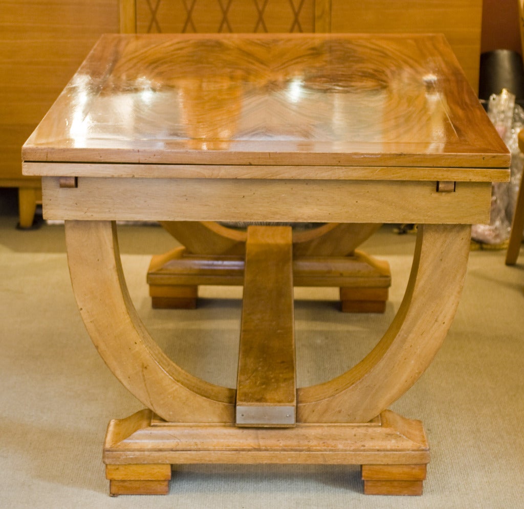 French walnut Art Deco table in the style of Rhulmann featuring brass plate detail and two retractable leaves.