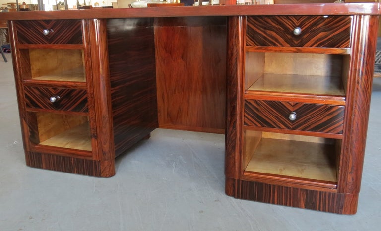 This French Art Deco desk is from the 1930’s.  The desk is completely veneered in macassar ebony.  The ebony is book matched on the drawer fronts, horizontal on the sides, back and top.  The desk has four drawers with chrome pulls and four finished