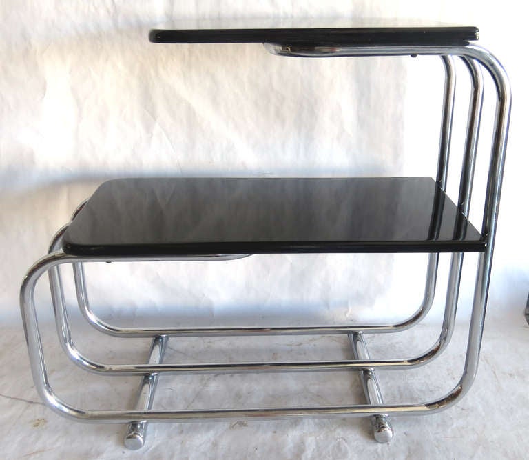 This pair of American Art Deco streamline black lacquer and chrome side tables were designed by Alfons Bach (1904 – 1999) for Lloyd Chromium Furniture, The Lloyd Manufacturing Company, Menominee, Michigan.  They are known as “T-57-A Table” in the
