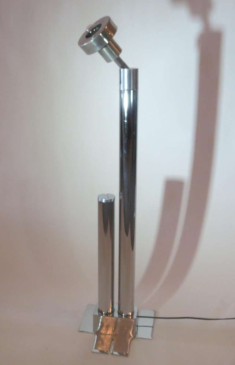 This striking mid-century modern stainless steel floor lamp was made in 1963 in his studio by British designer George Ciancimino (1928-). It is one of an edition of three made. The lamp has a swiveling head which can act as a torchiere for ambient