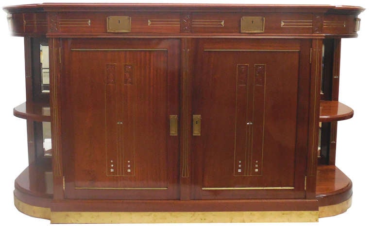 An important Belgian Art Nouveau dining set attributed to Henry Van De Velde (1863-1957). The set consists of a dining table with three leaves, eight chairs, a buffet and a sideboard. This magnificently crafted solid mahogany set features hand