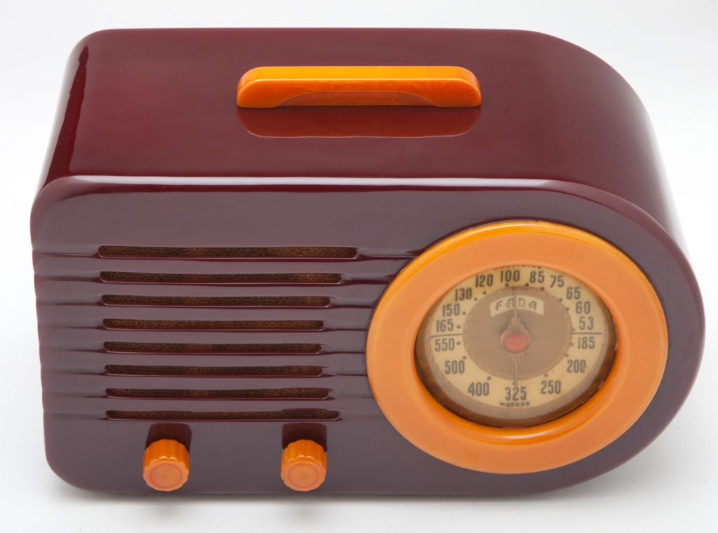 This streamline FADA “Bullet” model 1000 American art deco radio has a Catalin case of deep plum with golden butterscotch colored handle, knobs and dial ring.  FADA coined the term “Fada-Lucent” to refer to their Catalin cabinets.  The “Bullet” was
