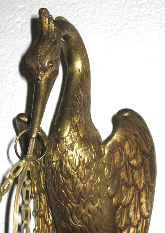 This superbly crafted pair of French art deco sconces date from the 1920s and are fashioned as a pair of storks.  Constructed of bronze with a gold dore finish, each bird holds an illuminated alabaster shade.  Each sconce is 16” high, 5” wide and
