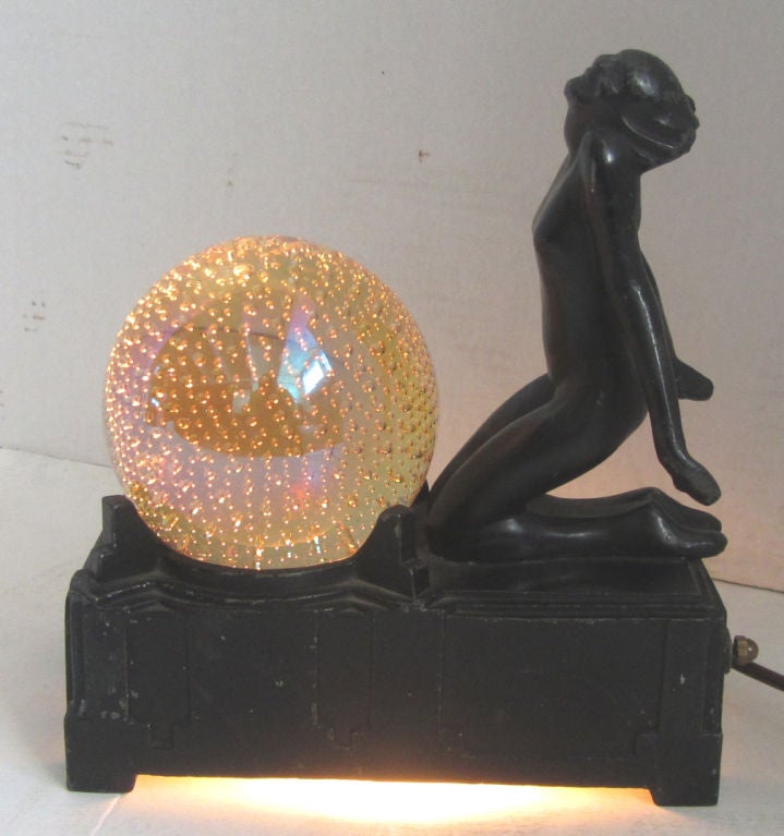 This original American art deco table lamp was designed in 1930 by sculptor Arthur Von Frankenberg for Frankart Inc. The lamp received design patent D81265 and features a nude kneeling before a four-inch diameter crystal ball in pale yellow with