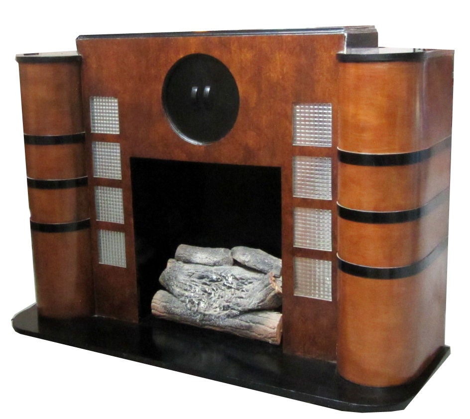 This 1930’s American art deco electric fire place is hot! And cool!  The “fire” isn’t real but the look is!  Constructed of burl walnut and straight walnut veneers and black lacquered wood, the fireplace has illuminated “glass” blocks, a “port hole”