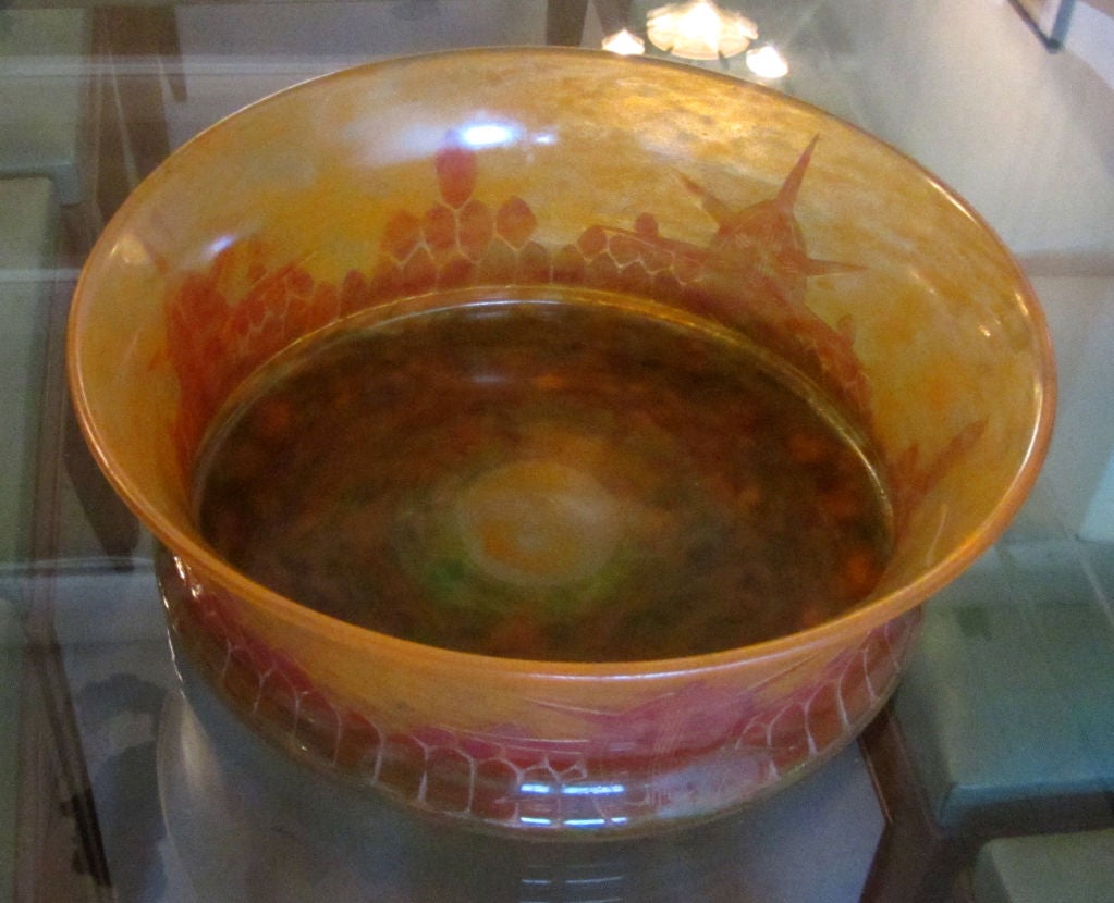 This French art deco cameo glass bowl was created by Charles Schneider (1881 – 1953) for his Le Verre Francaise line.  The low, waisted bowl is uncommon in his oeuvre.  It is cut in the Tortues pattern in red and green on an orange Tango ground
