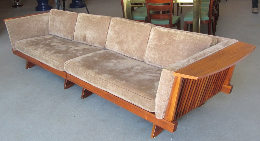 George Nakashima (1905 -1990) designed this mid century modern design long spindle side sofa ca. 1950 for his Origins line, produced by the Widdicomb Furniture Company, Grand Rapids, Michigan. The sofa, number 252W in solid walnut, is in excellent