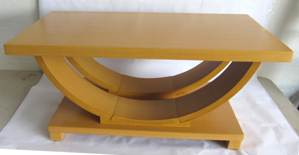 This sharp American art deco streamline coffee table was made and retailed by the Modernage Furniture Company in New York City, the largest “moderne” furniture store in America in the 1930’s. Constructed of European poplar veneers, the two curved