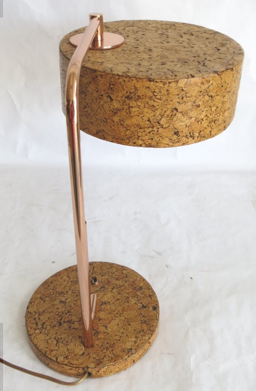 This rare table lamp was designed by Kurt Versen (1901 – 1942) for the Kurt Versen Company in 1935.  The base and shade are covered in cork and the shaft and support are in polished copper.  The shade swings out from the shaft to provide a wider