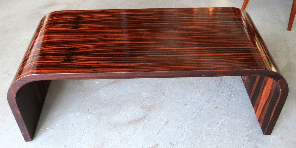 This stunning American art deco coffee table in the form of an inverted “U” is clad in old growth macassar ebony veneers.  The table has been lovingly refinished and is in excellent condition.  The table is 47” long x 20” wide and 17” high.