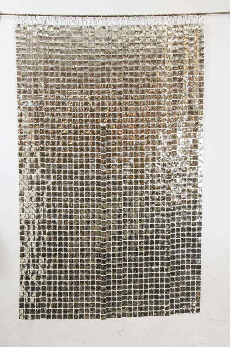 Gorgeous silver colored space curtain by Paco Rabanne. The curtain is comprised of the same links that he used on his iconic mini dresses: plasticized metal squares joined by plastic gold colored clips. A versatile accent piece, it can be a wall