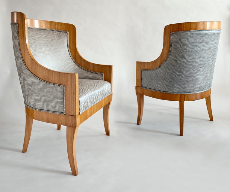 Elegant pair of Swedish Art Deco bergeres designed by architect Carl Bergsten for the luxury ocean liner M/S Kungsholm. The chairs are documented in the 1928 photograph of one of the Kungsholm's reading rooms. Chairs are elm wood veneer, newly