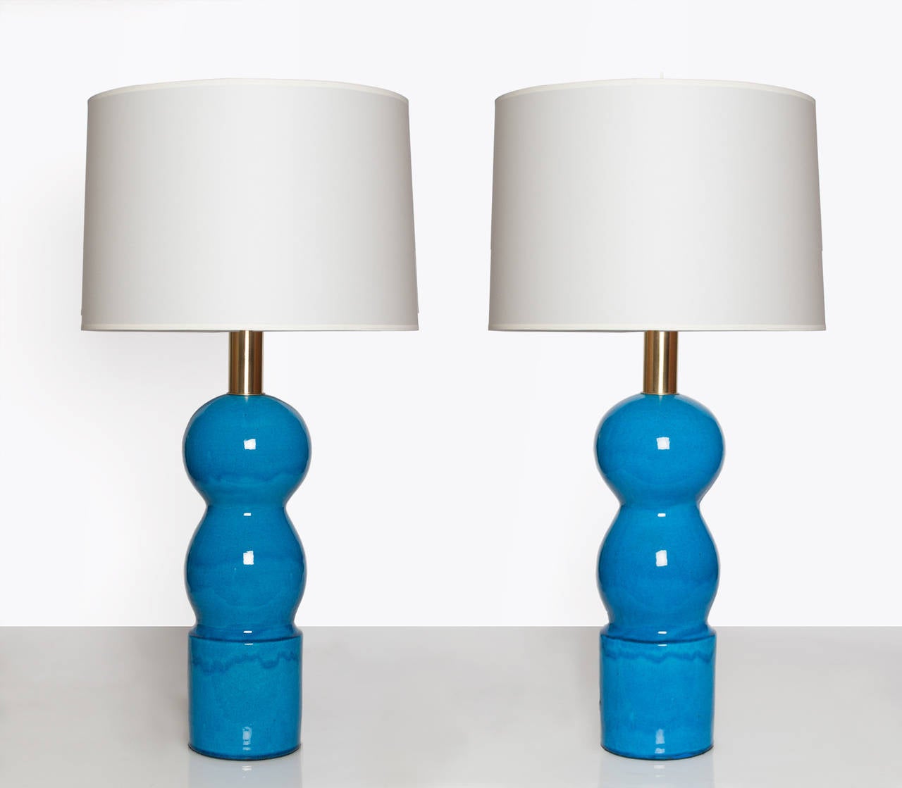 Large pair of Scandinavian Modern ceramic lamps in a bright blue glaze. Lamps have polished and lacquered stem and double cluster sockets, new rewired. Made at the Herman August Kähler Pottery, Nestved, Denmark, signed with Kahler mark and A.