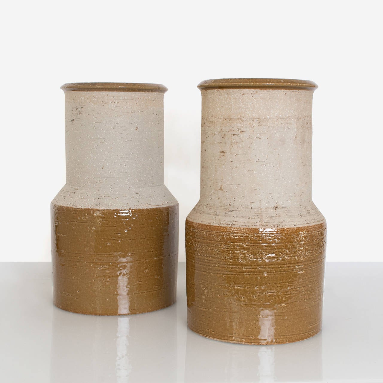 Pair of Scandinavian Modern large minamalist form studio vases by Hertha Bengtsson for Rorstrand, Sweden. These vase are of charmotte clay and are partially glazed on lower half and rim. Designed circa 1962. May be purchased separately. 
 
H: 15