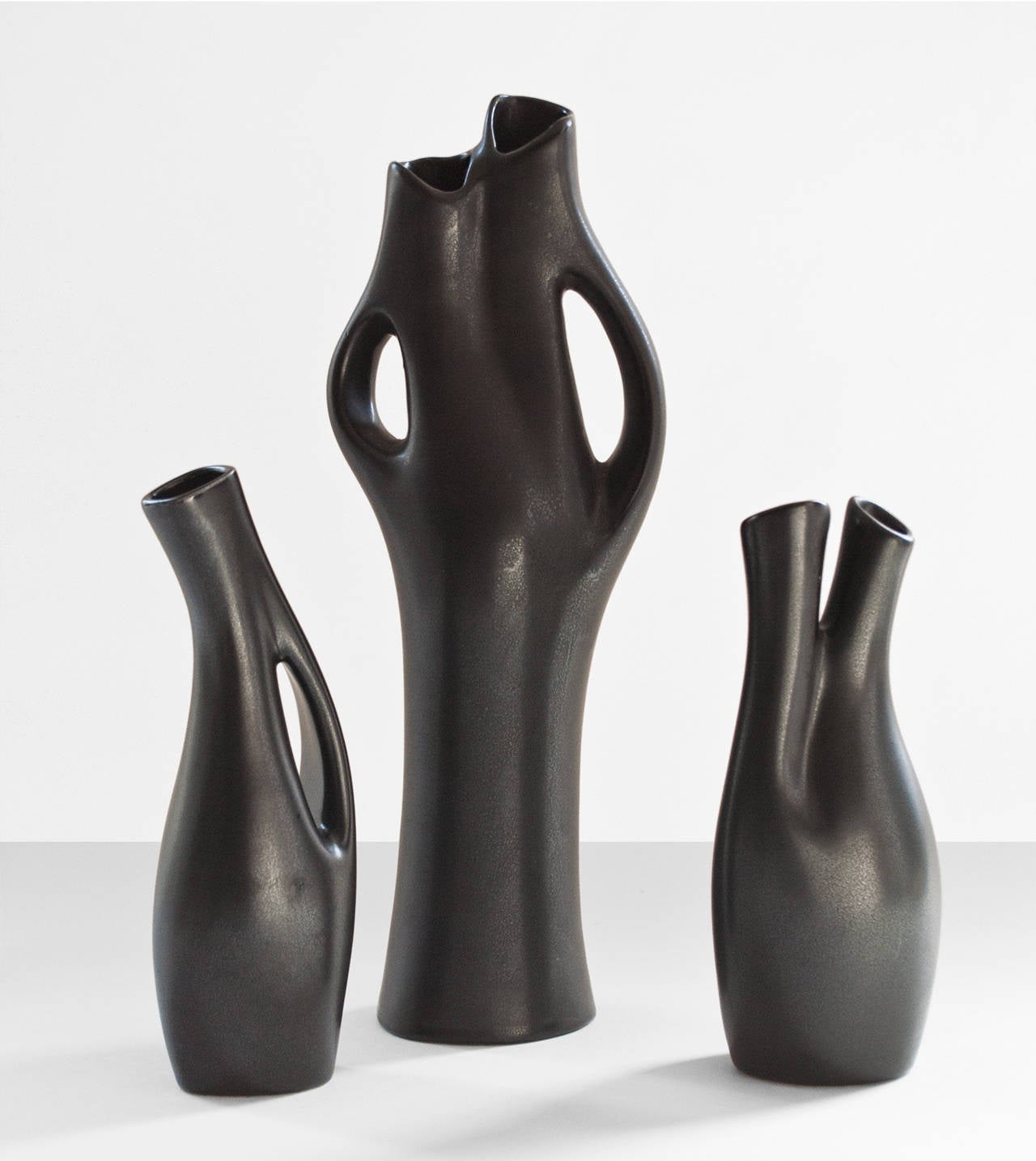 Lillemor Mannerheim designed vases for Gefle Porcelain Company. She was noted for her abstract shapes and black glazing refereed to as Mangania. Her works are represented at the National Museum in Stockholm. These vases are signed, Tallest H: 12.5