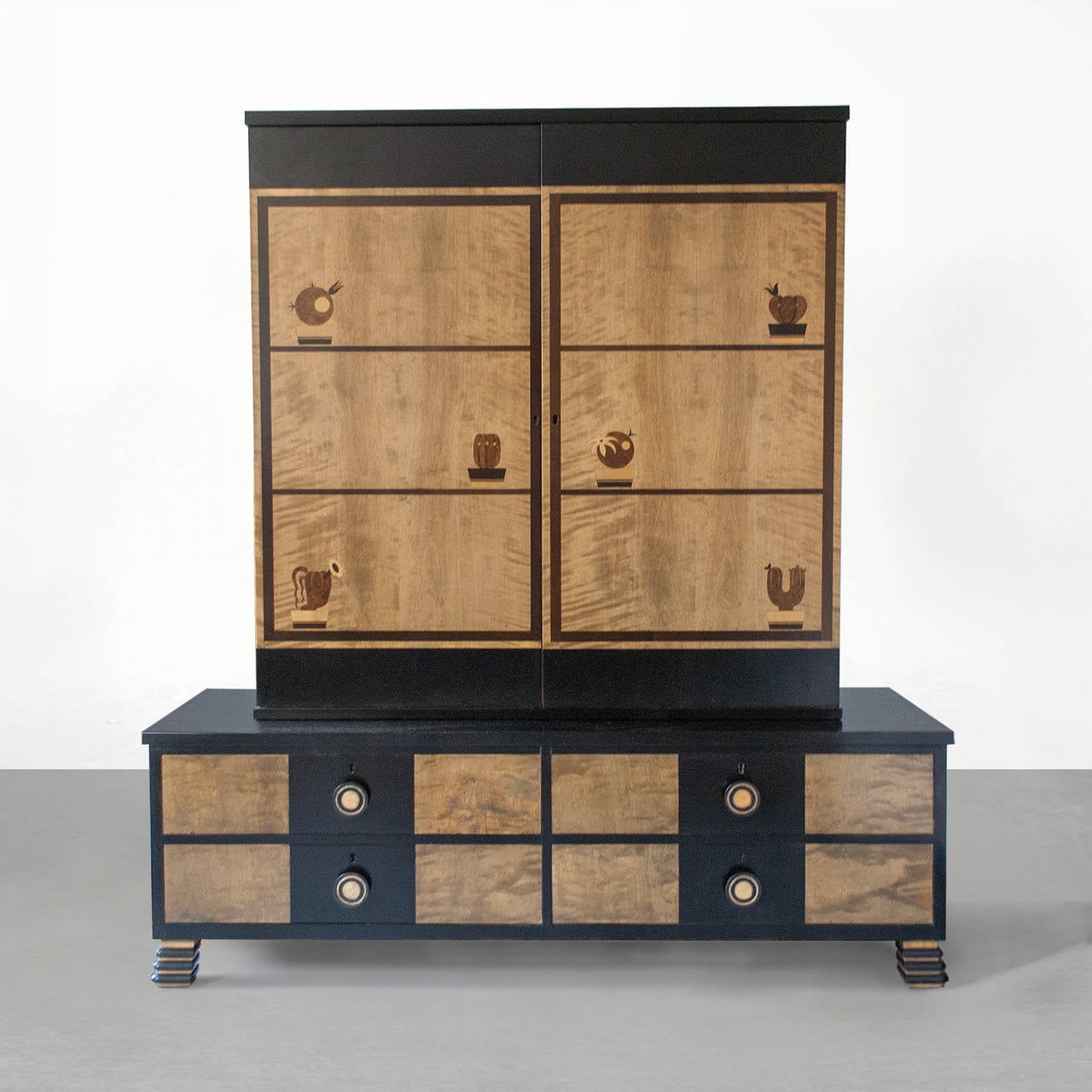 Swedish Art Deco two-part cabinet with marquetry depicting six potted cacti. The cabinet has two doors with six adjustable shelves; the lower part has four drawers with carved pulls. Both parts consist of polished and stained birch. Designed by