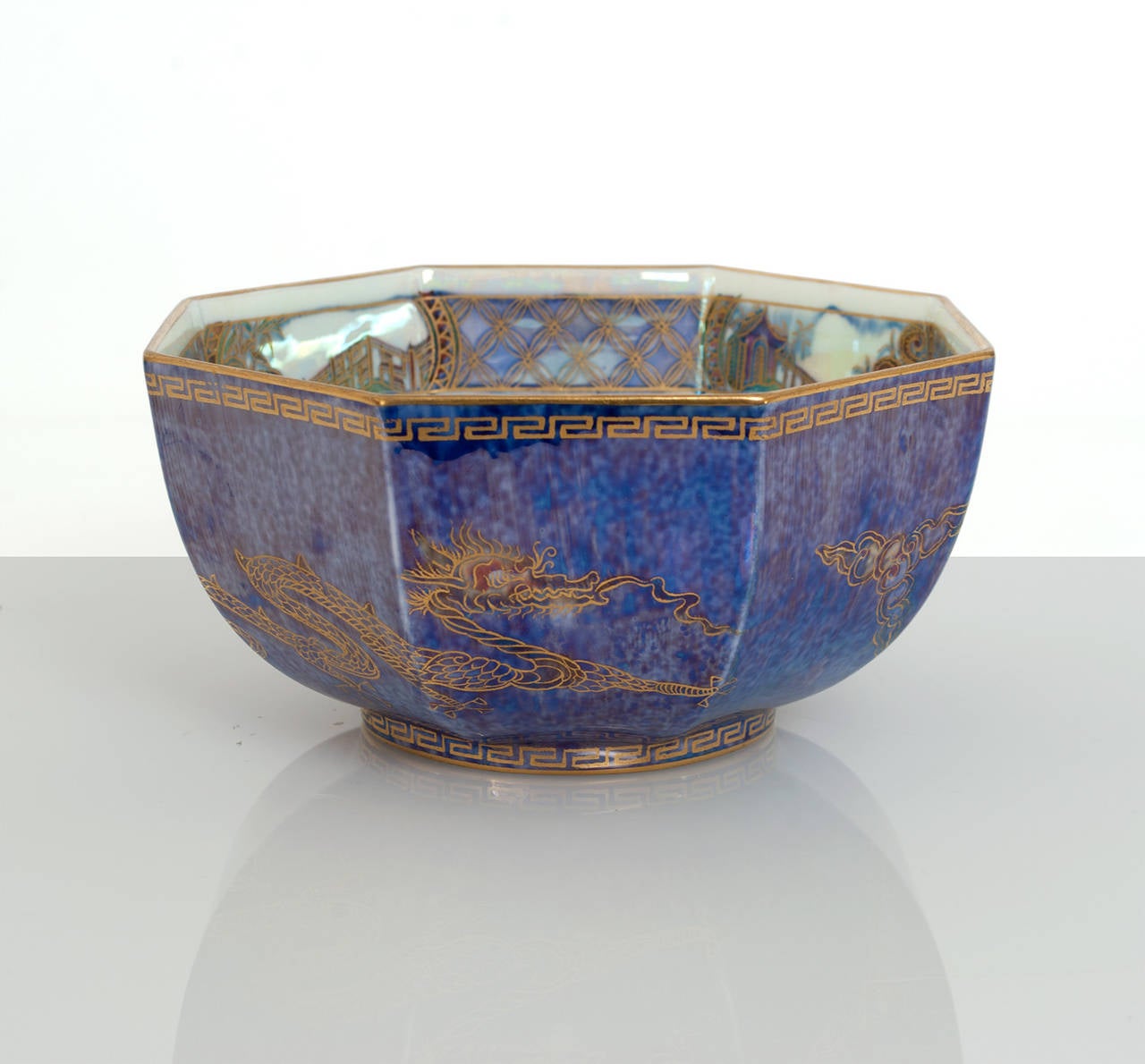 A very finely decorated octagonal Wedgwood Fairyland Lustre bowl designed by Daisy Makeig-Jones. The bowl's mottled blue exterior is decorated with two gilded celestial dragons and a gold dragon at the inside center. Excellent condition. Measures: