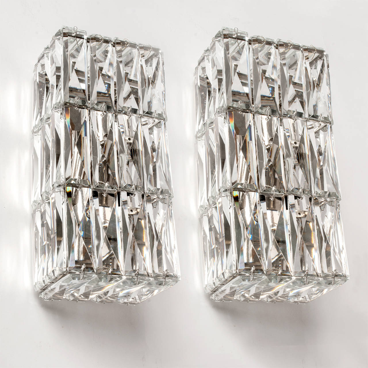 Pair of mid-century Austrian faceted crystal sconces made by Bakalowits & Sohne. Sconces mount with nickel plated and lacquered back plates, each with two sockets. New rewired for use in the USA. Height: 10”, width: 4.75”, depth: 4