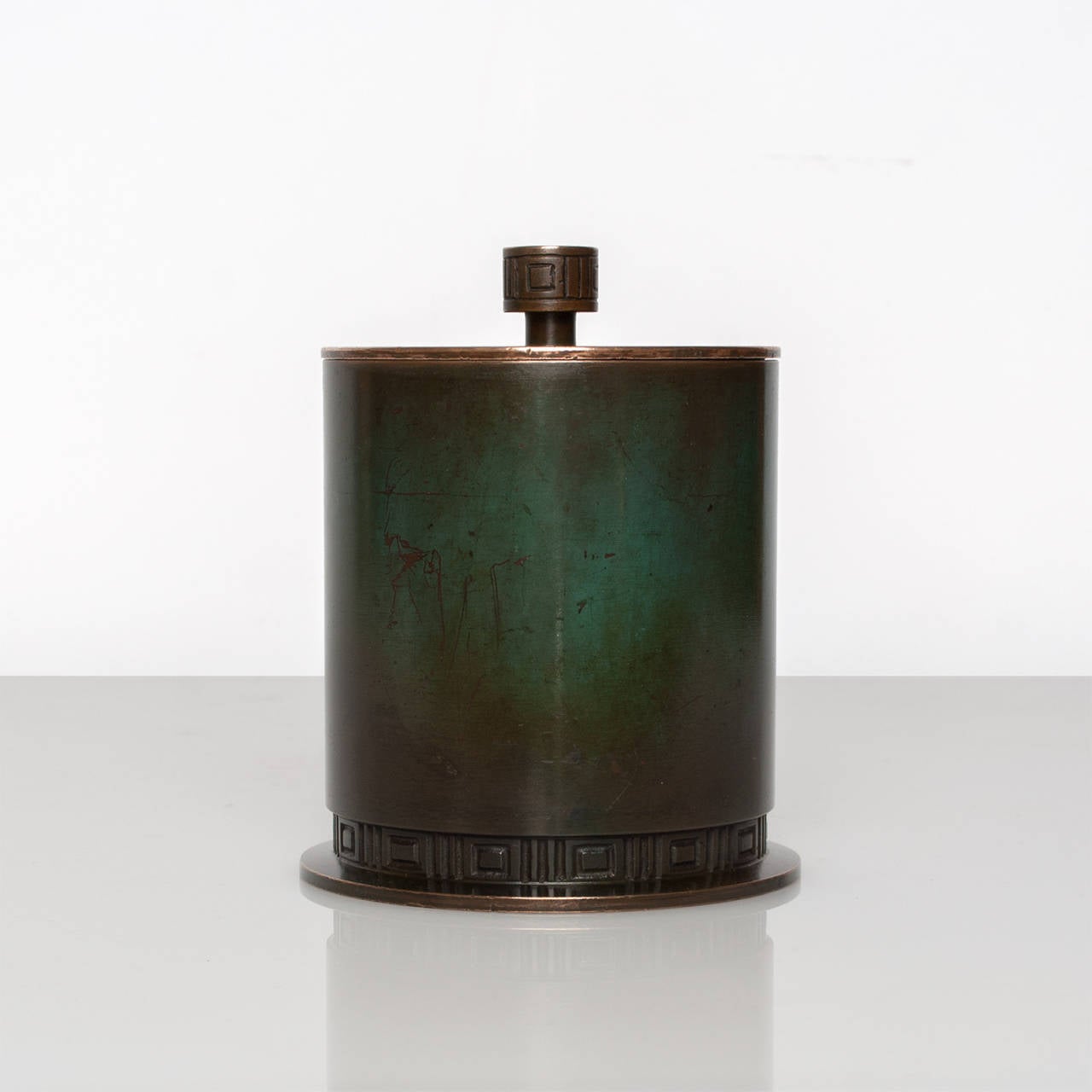Swedish art deco bronze tobacco jar with lid. Hand cast at Guldsmedsaktiebolaget, GAB and patinated with a deep to medium green. The jar's column form is sparsely decorated with a meander motif at the base and the lid's pull. The inside of the jar