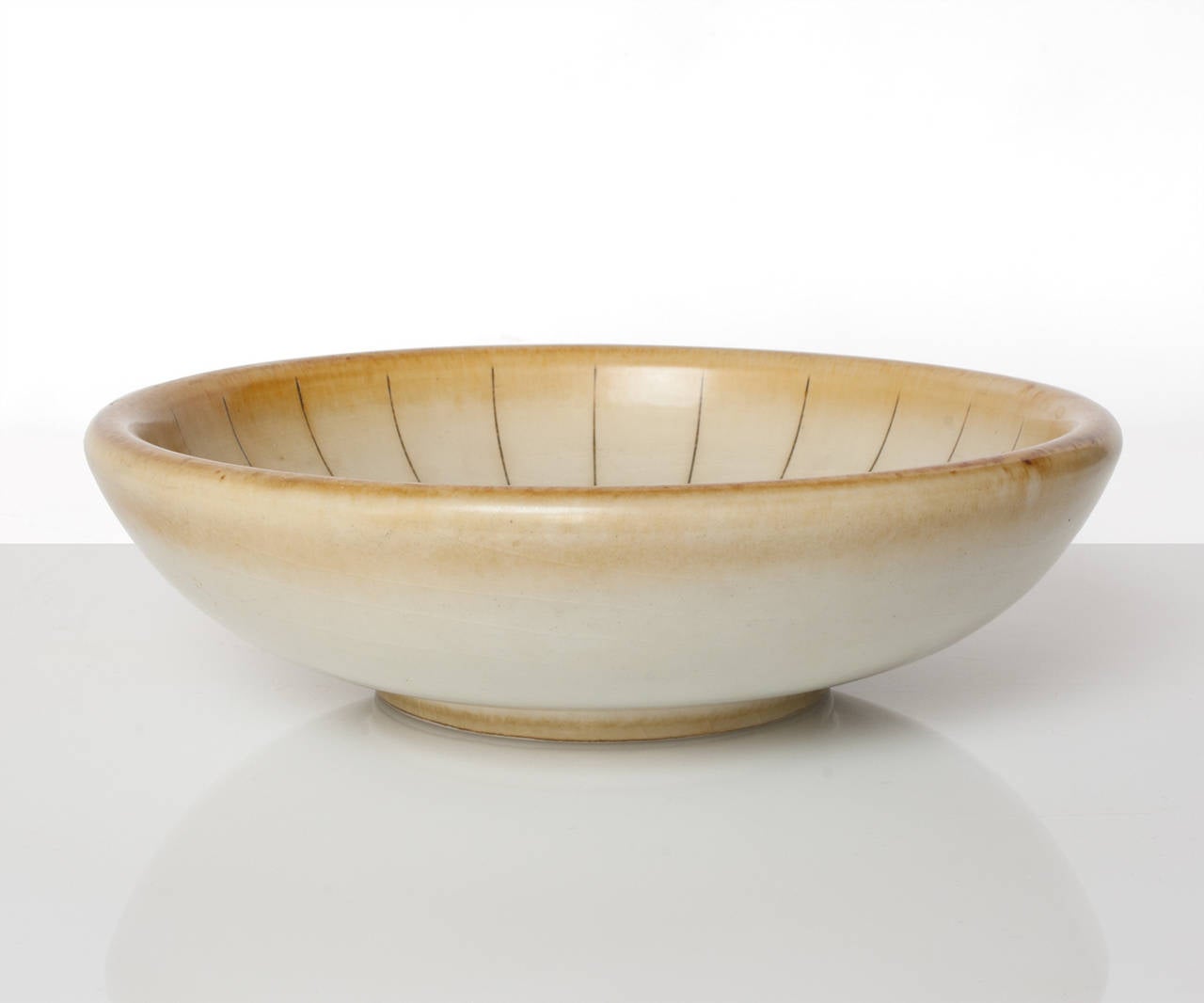 A Scandinavian Modern, Swedish Art Deco ceramic footed bowl in a pale golden glaze with incised lines. Made by Gertrud Lönegren at the Rorstrand studios. Measures: Diameter 9.75