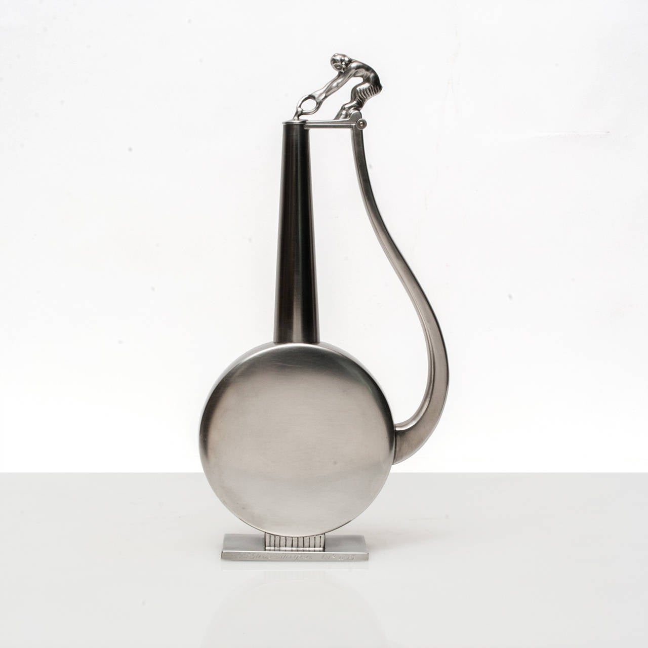 Swedish Art Deco solid polished pewter bottle with stopper. A figure of a Satyr or Faun sitting atop pulling a ring serves as a handle. An inscription is engraved at the front of the base. Made by GAB (Guldsmedsaktiebolaget) and stamped G8 (1933)