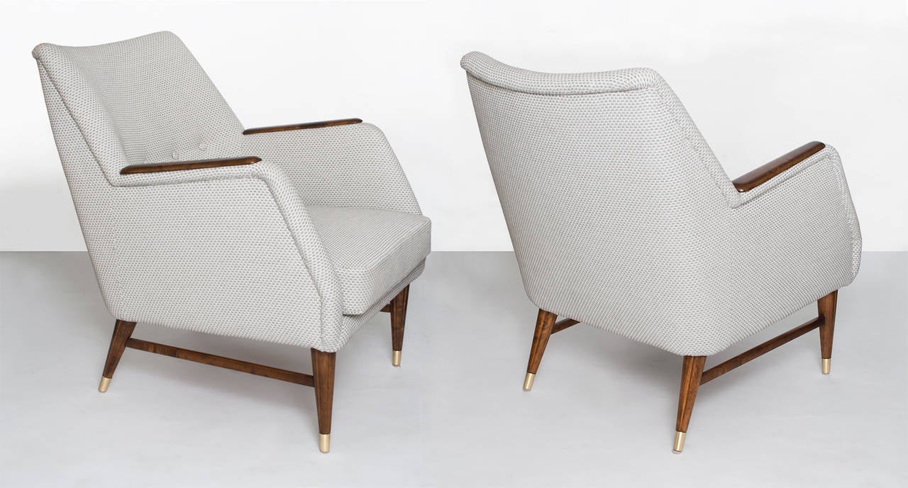 Pair of sleek Swedish mid-century modern armchairs with light gray fabric, newly upholstered, The chairs are completely restored and have carved and stained solid  birch frames with rear and front reeded legs with polished brass sabots.
 
Height: