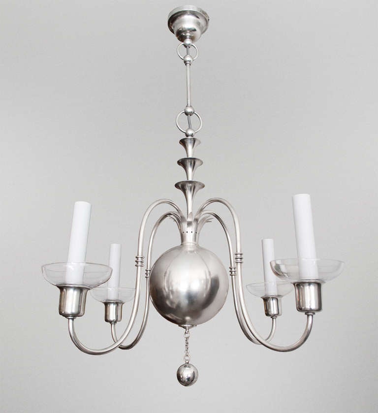 A fantastic 4-arm silver plated brass Swedish Art Deco chandelier designed by Elis Bergh for C. G. Hallberg, Stockholm, Sweden circa 1920's. The four arched arms sprout from a crown which rest on a large center sphere.  A stylized fountain joins a