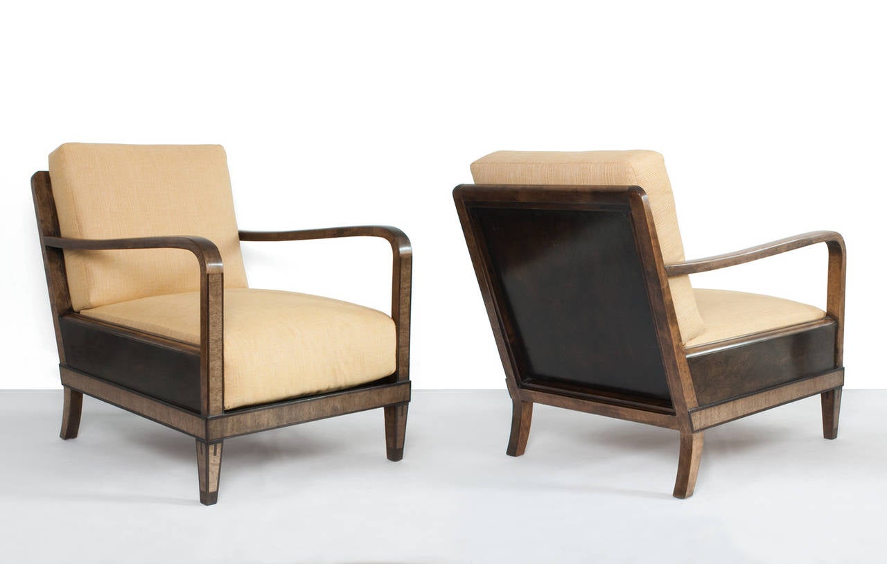 Pair of Swedish art deco armchairs with stained birch frames and mahogany details around the base, legs and arms. Newly restored and newly upholstered loose cushions. Dimensions: Depth: 33, Width: 24.5, Height: 31.5
