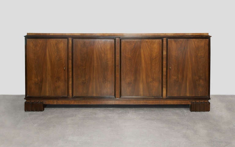 Danish Art Deco 4-door sideboard cabinet with walnut veneer designed by Georg Kofoed.  The cabinet has 11 internal drawers in Nordic birch wood veneer in one compartment and a single shelf in the other.  Intricate moldings detail the doors as well