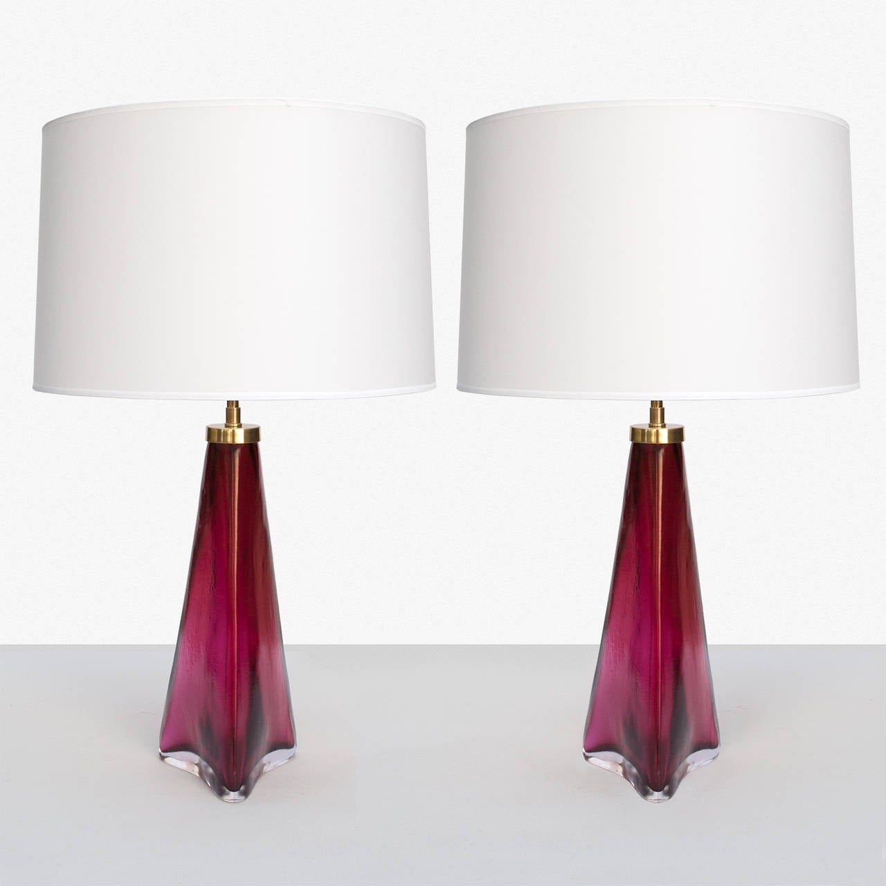 Gorgeous pair of Swedish table lamps in red and clear glass with matt, acid treated finish. Signed Orrefors on the brass cap, lamps retains original paper label. Wired for the US with high-end double cluster socket hardware of polished lacquered