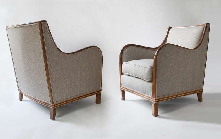 Elegant and comfortable pair of Swedish Art Deco bergères by  Oscar Edv. Ekelund in Wirserum, circa 1930. Chairs are solid stained birch with carved wood details which wrap around the base.  The front legs feature a raised detail in a lighter wood.