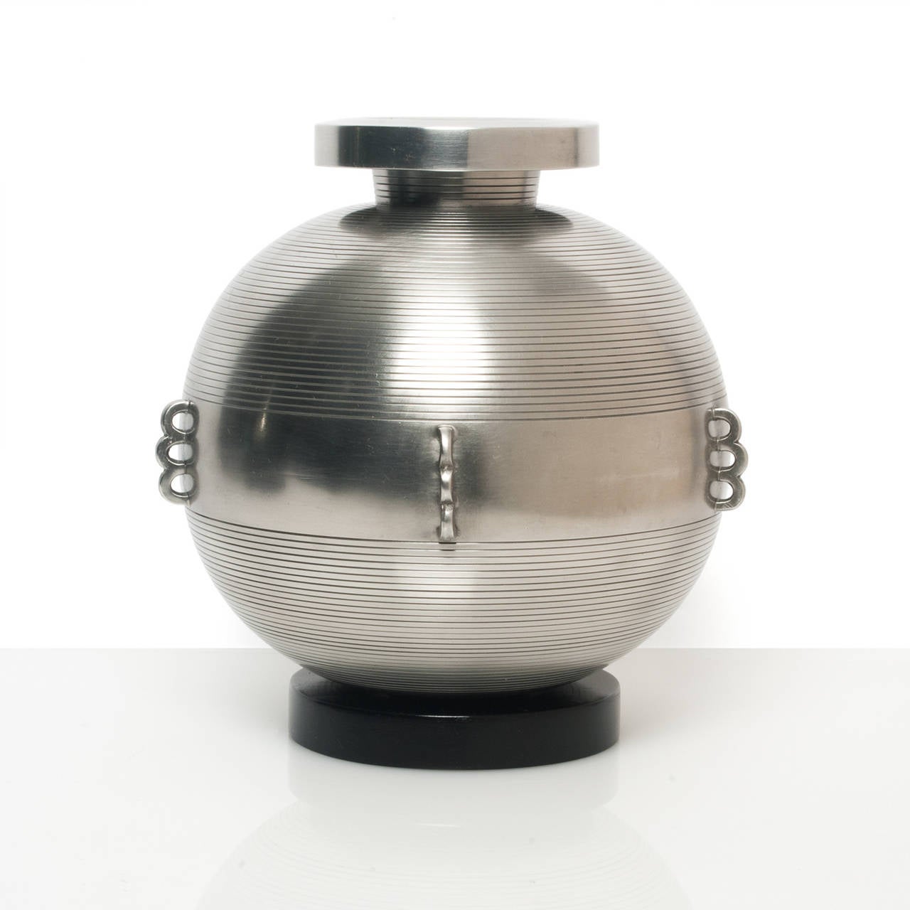 Scandinavian modern, Swedish Art Deco polished pewter vase on a black lacquered wood base. The vase is detailed with finely detailed horizontal lines and a center band with raised arches. Designed by Sylvia Stave for C.G. Hallberg circa 1934,