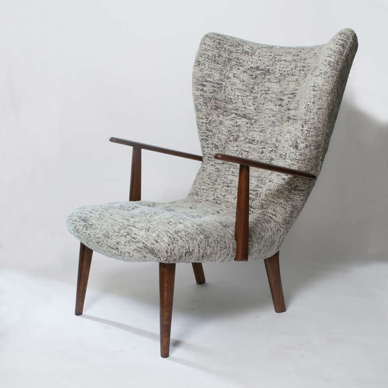 A dramatic Danish mid-century Scandinavian modern wing-back chair in walnut stained teak wood. A classic example of the softer side of modernism, new restored and newly upholstered in a gray heathered velvet fabric.
 
Height: 37.5