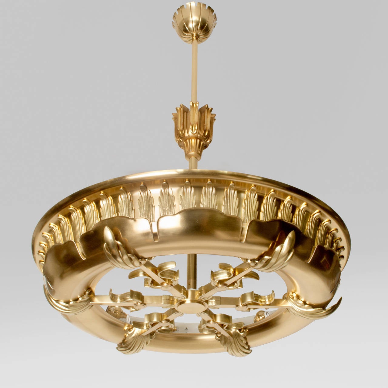 Large Scandinavian Art Deco ring form polished brass pendant. The fixture's style was inspired by Neoclassicism which is reflected in its ordered use of decorative elements such as acanthus leaves, lyres and a sunburst design. There are 12