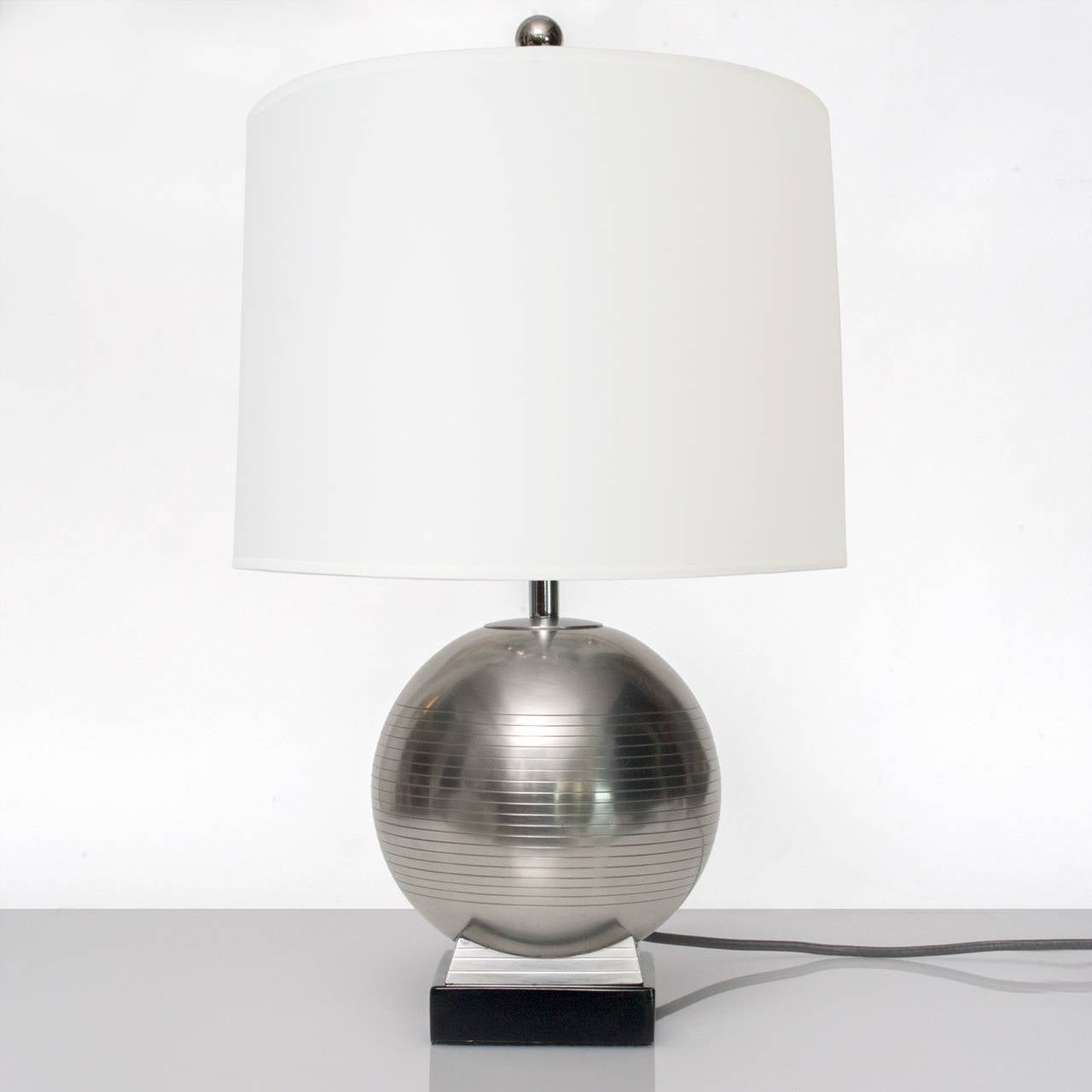 Spherical Swedish Art Deco pewter table lamp on a lacquered wood plinth detailed with a series of horizontal groves. Made by G.A.B. (Guldsmedsaktiebolaget) circa 1930. Newly polished, lacquered and rewired for the USA, with a nickel plated double