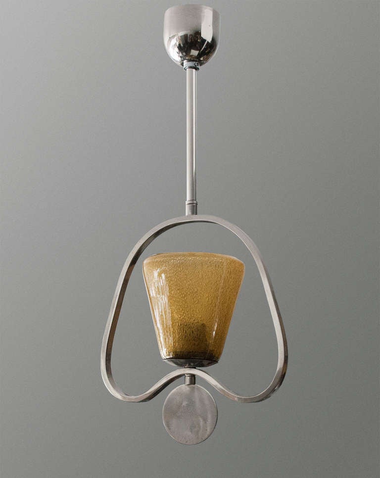 A Swedish Art Deco lantern with an amber glass shade and a chromed plated metal frame.  The frame features an over-sized disk shaped finial. Original canopy, newly electrified with a single standard socket. Height: 22.5
