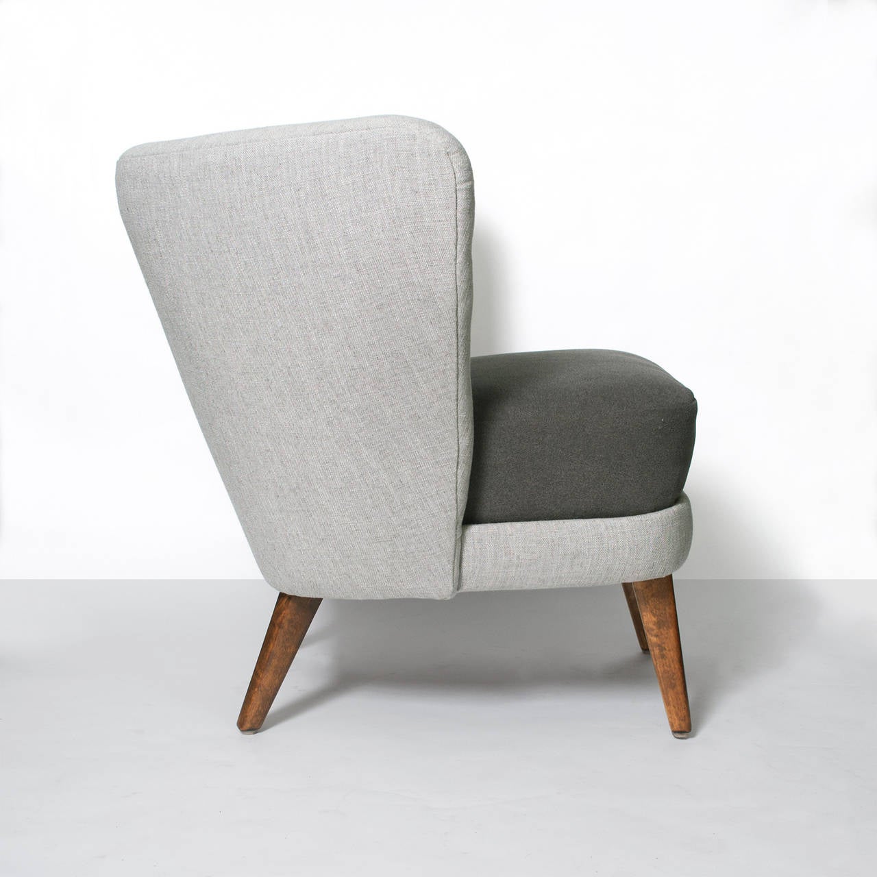 Carved Scandinavian Modern wrap wing chair with internal carved wood arms.