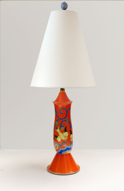 High quality porcelain Art Deco table lamp with stylized floral and flying birds motif. Vibrant blues, green and yellow hand pained on an orange ground highlighted with gold details. Overall height 26