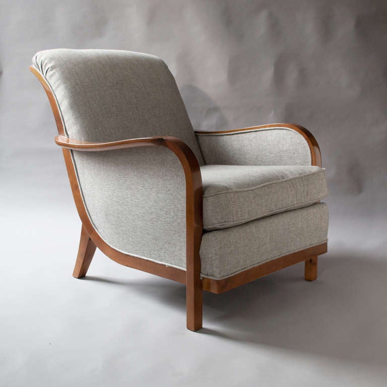 Elegant pair of Swedish art deco armchairs with a graceful scroll backs raised on sabre back legs. The chairs are solid stained birch and feature a cantilevered platform seat with upholstered cushion. Produced by Wilhelm Knoll, Malmo, 1933. Newly