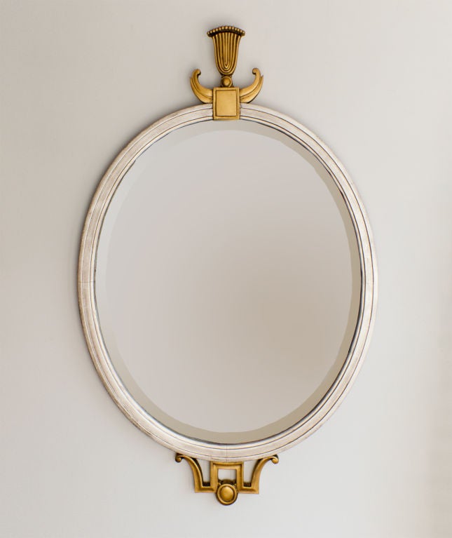 Elegant 1920's Swedish Art Deco gilt and silver leaf oval wood mirror. Original mirror glass has a beveled edge. The frame is decorated with stylized carved details in gilt wood. Height: 35