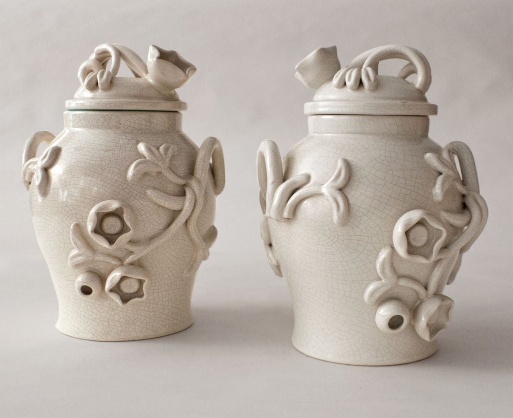 Swedish Art Deco ceramic covered urns with hand applied decorates in white crackle glaze. One urn has a white interior the other celadon. Designed by Eva Jancke Björk for Bo Fajans, circa 1930-40. Height 13“, Diameter 9.5“.