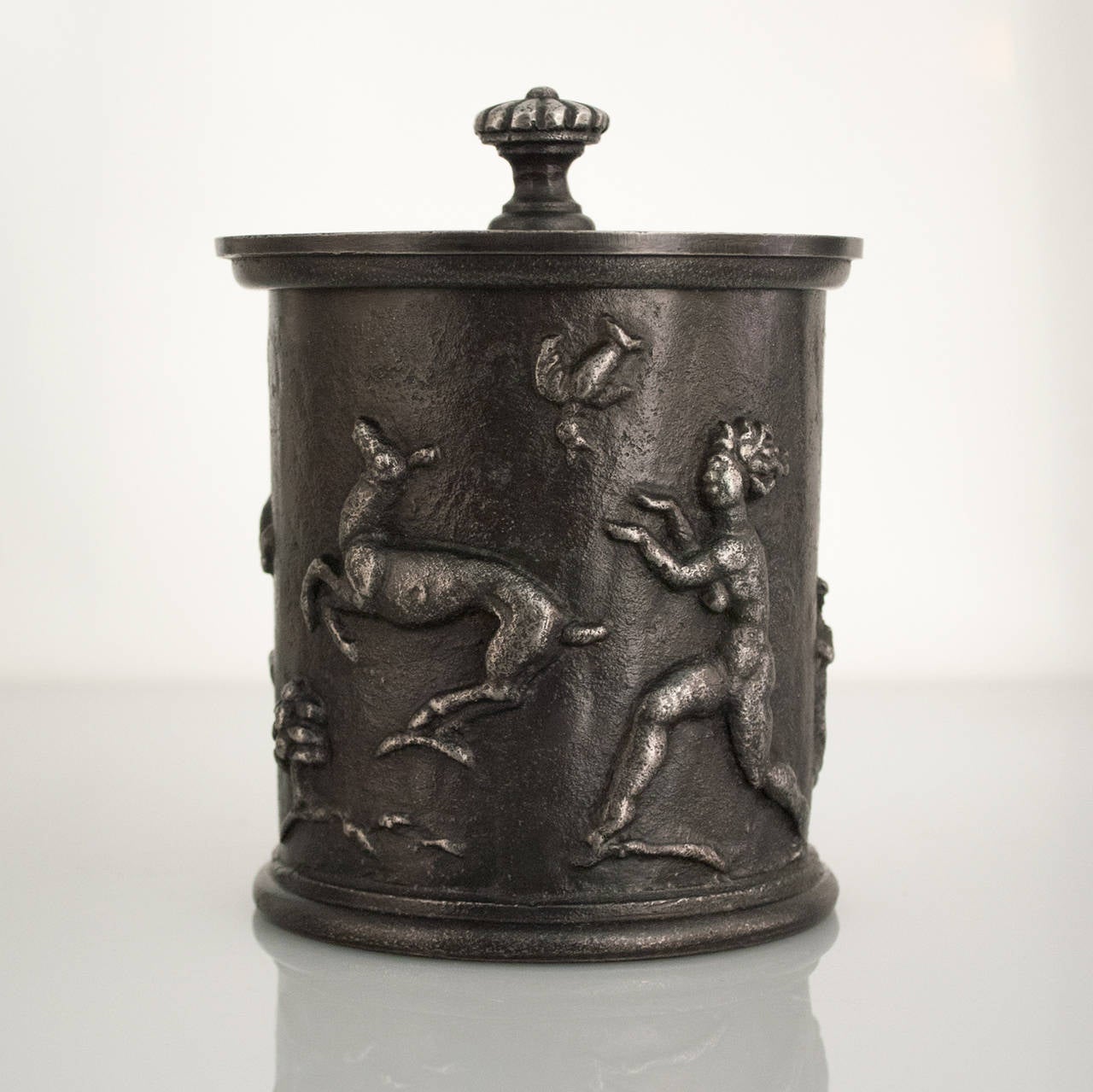 Swedish art deco (Swedish Grace) cast iron tobacco jar with lid. The exterior is decorated with a male and female figure, a stag, a doe and a bird. Designed by Carl Elmberg for famed ironworks company Näfveqvarns Bruk. Total height: 6.75