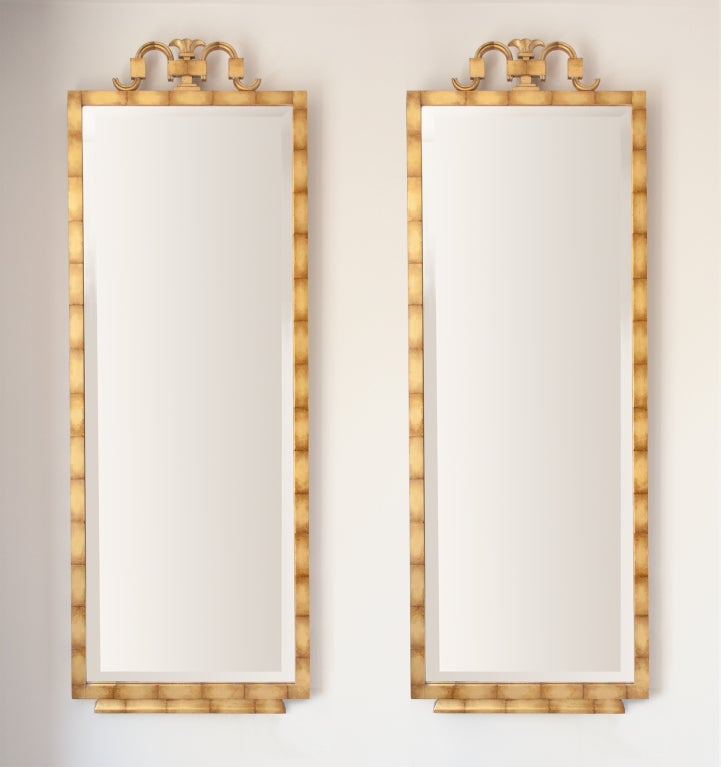 Elegant pair of Scandinavian Modern, Swedish Art Deco mirrors by Axel Einar Hjorth, for Bodafors circa 1923. The wood framed mirrors are finished in gold leaf and feature carved details on the crown and foot. Excellent restored condition. Height: