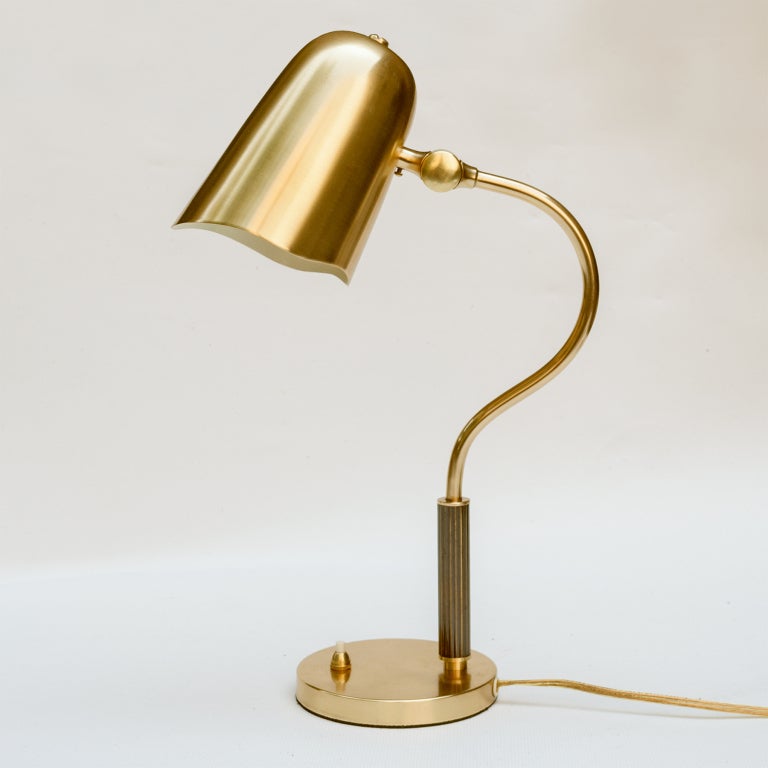 Swedish art deco desk or table lamp in polished brass with articulated shade. The lamp has a reeded column in patinated brass and a switch on a round foot. Made in Sweden circa 1930, newly polished, lacquered. Newly rewire with one standard socket