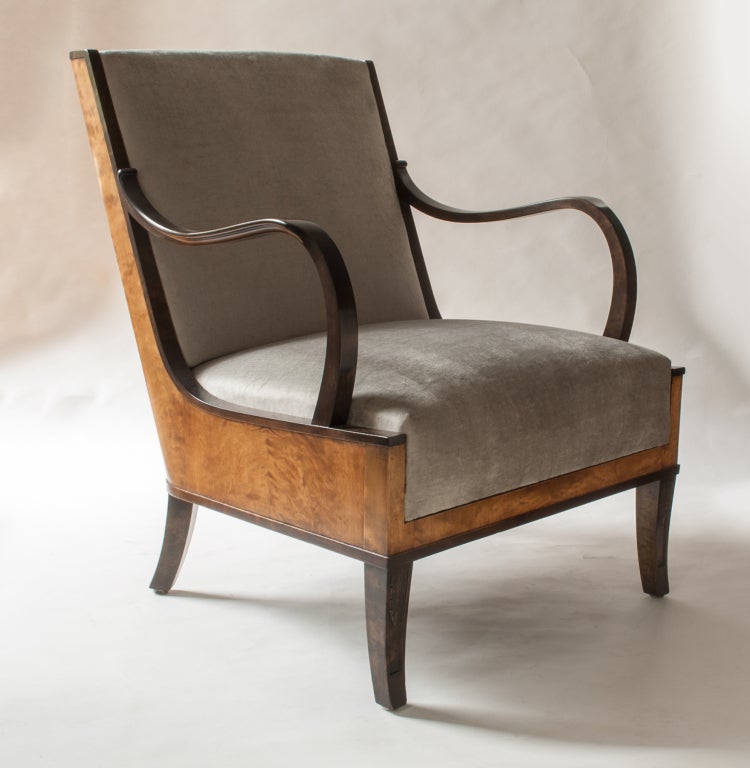 Elegant pair of Swedish art deco armchairs designed by Erik Chambert. Chairs feature a sleek wood veneered frame, gently scrolling arms and carved saber front and rear legs. Roomy and very comfortable chairs. Newly restored, new upholstery in