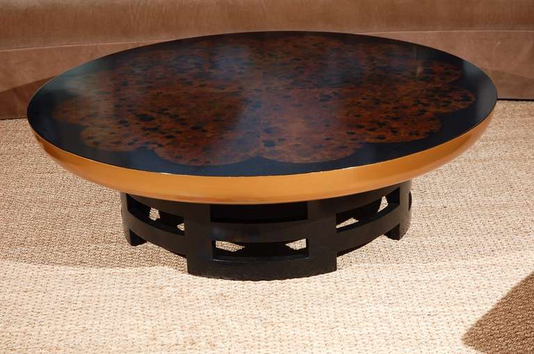Winning the Aid Award for design, Theodore Muller's Kittinger coffee table has a custom-made black thick round wood top with a gold finish bull-nosed edge over a dark wood base. Lacquer top. Truly stunning piece with grandeur and beauty.