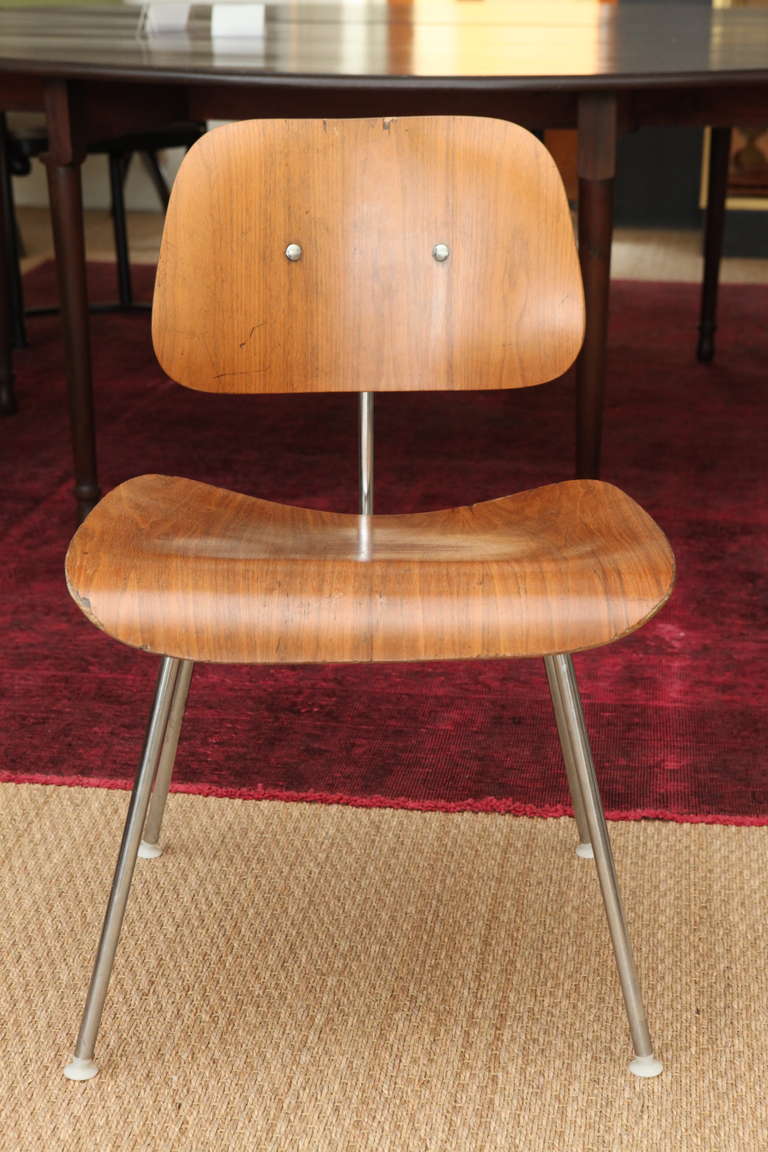 The iconic, low-slung DCM chair from Herman Miller, designed by Charles and Ray Eames in 1946, consists of their recognizable and ingenious molded, bent plywood, which cradles the body perfectly. The legs are metal and the wood finish is ash. These