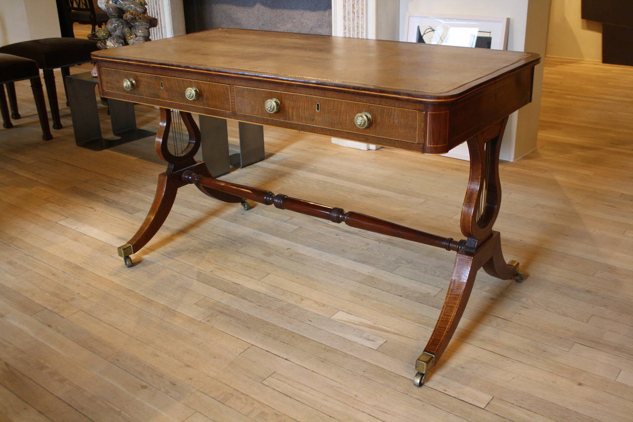 Regency brass-mounted harewood trestle table with leather top.