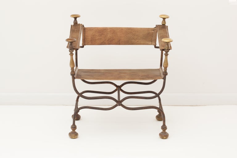 Fantastic late 19th century hand forged iron curule form chair with solid bronze finial details on arms, back and feet with new metallic bronze leather seat and back.